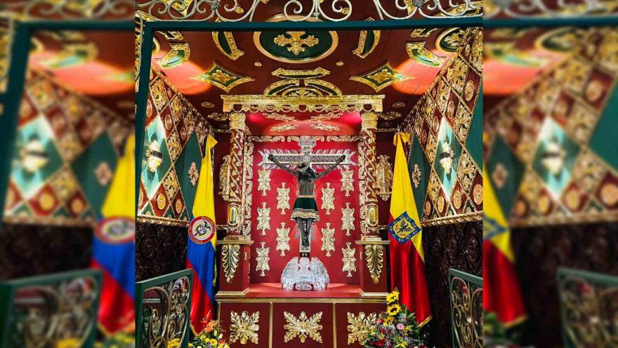 Figura del denominado “Señor de los milagros” en un espacio decorado y rodeado por las banderas de Colombia y de Bogotá.
