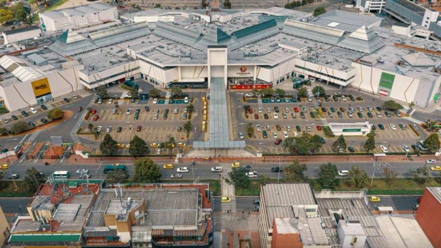 Plano general de la fachada de una gran zona de edificaciones de mediana altura, con una amplia área de parqueaderos.