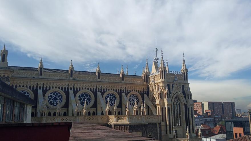 Panorámica de lado de la parte alta de la iglesia de Chiquinquirá. Destacan las puntas de las torres de estilo gótico cerca del cielo azul. 