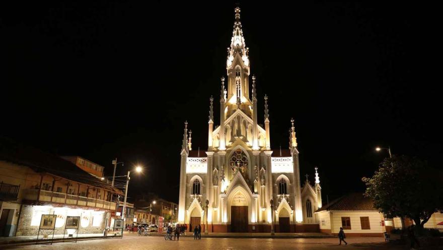 Vista de noche de la fachada de la iglesia, iluminada con luz artificial. 