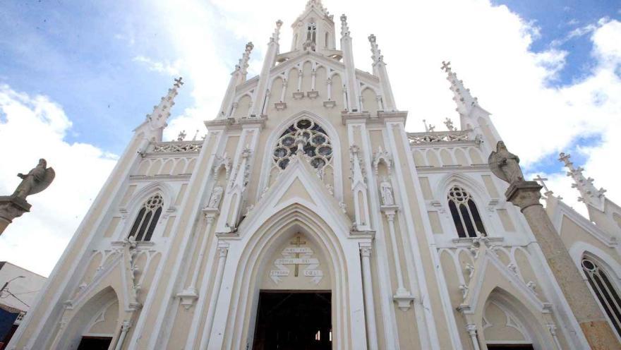Primer plano de la fachada de la iglesia vista desde abajo. Destacan sus hermosas puntas y la figura de dos ángeles en cada extremo.