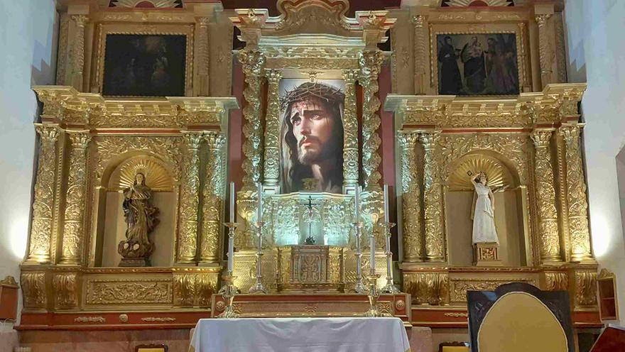 View of the altarpiece, featuring the face of Jesus Christ at the center, framed by beautiful and intricate golden ornamentation.
