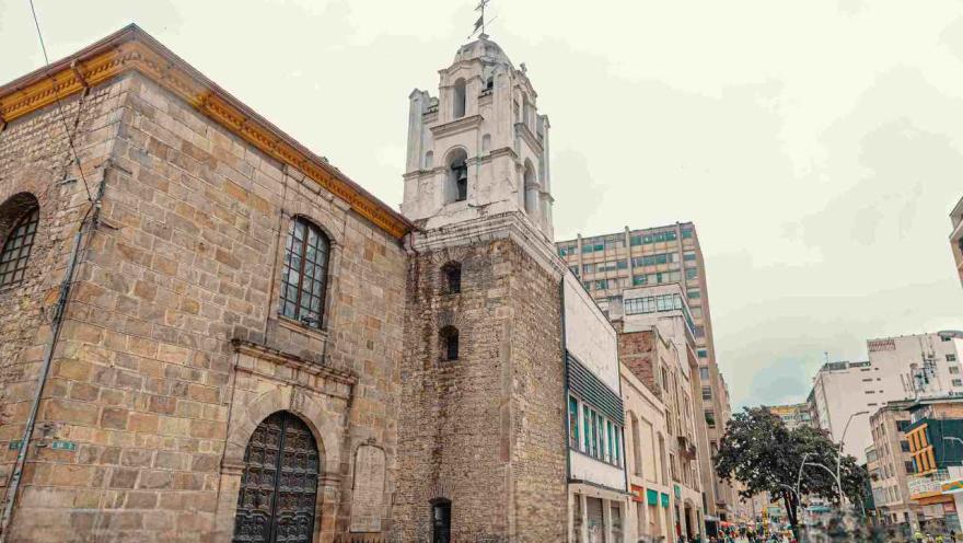 Side view of the church's facade. Some people can be seen in the street in the background.