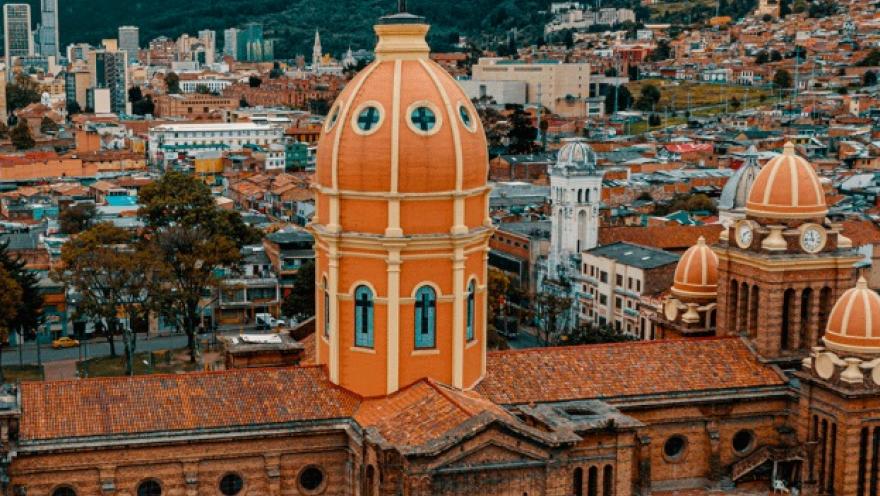 Primer plano de la torre de una iglesia vista desde arriba, de forma ovalada y de color naranja.