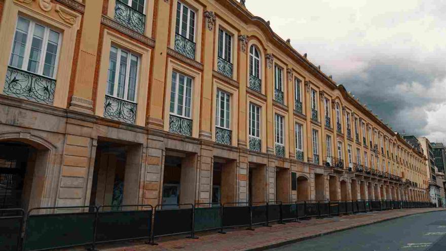 Plano general de la fachada exterior del palacio. Se observan muchas puertas en piedra en el primer piso y muchas ventanas en el segundo. 