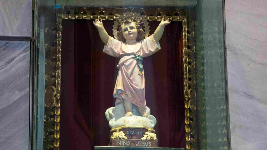 Primer plano del Divino Niño Jesús con sus brazos extendidos.