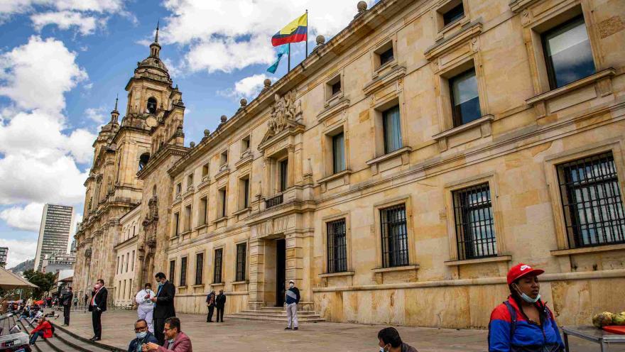 Plano general en vista lateral del edificio al lado de la Catedral Primada. Hay algunas personas alrededor.