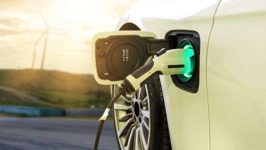 Primer plano de dispensador de electrolinera que carga un automóvil.