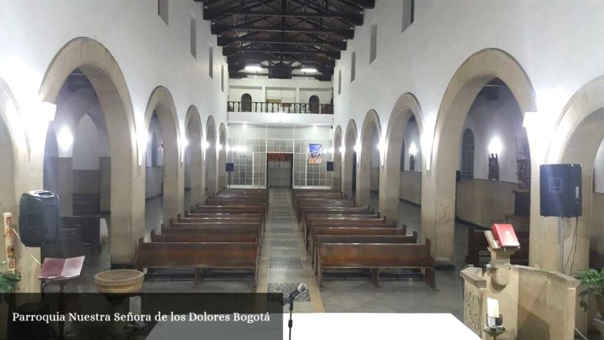 General interior view of the church from the altar, showing several arched columns and two rows of wooden pews. 
