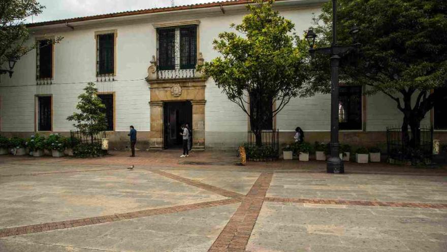 An outdoor patio with a building in the background, surrounded by greenery and a peaceful ambiance.