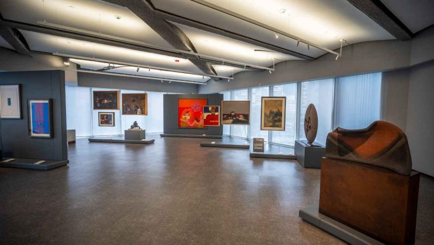 Una galería de arte con diversas obras expuestas en las paredes y en pedestales.