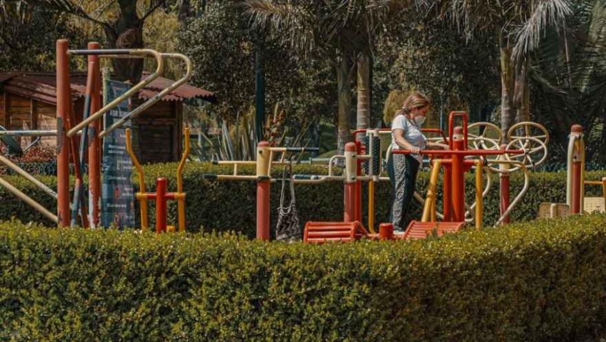 Una mujer juega en un equipo de parque infantil, disfrutando de un día soleado y divertido.