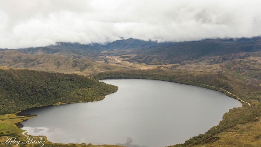 Gran laguna gris en medio de montañas.
