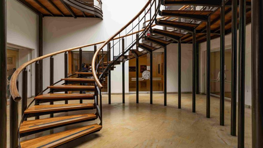Escalera de caracol en un edificio, combinando madera y metal en su diseño elegante y moderno.