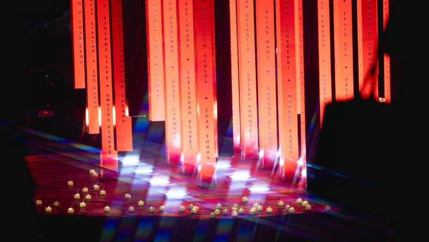 Una luz roja brilla en un escenario iluminado por varias luces.
