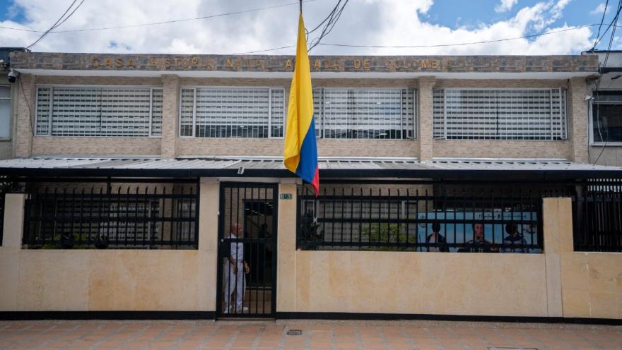 Fachada de la Casa de Historia Naval Armada de Colombia, un edificio de dos niveles con ventanas amplias protegidas por rejas. En el centro ondea una bandera de Colombia frente a la entrada principal, que está cerrada con una reja negra.