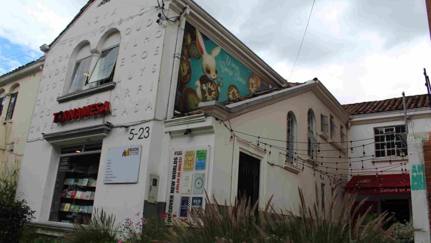 Fachada de la librería Tornamesa, edificio blanco con murales, carteles de libros y entrada visible desde la calle.