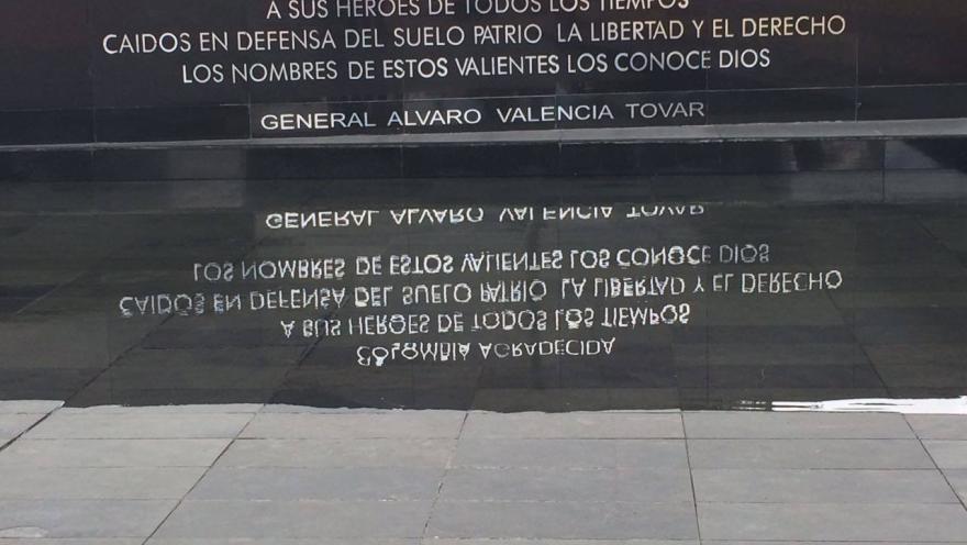 Placa conmemorativa a héroes caídos con inscripción visible en mármol negro y letras blancas con su reflejo en agua. Hay una leyenda que dice: “COLOMBIA AGRADECIDA A SUS HÉROES DE TODOS LOS TIEMPOS CAÍDOS EN DEFENSA DEL SUELO PATRIO, LA LIBERTAD Y EL DERECHO LOS NOMBRES DE ESTOS VALIENTES LOS CONOCE DIOS. GENERAL ÁLVARO VALENCIA TOVAR”