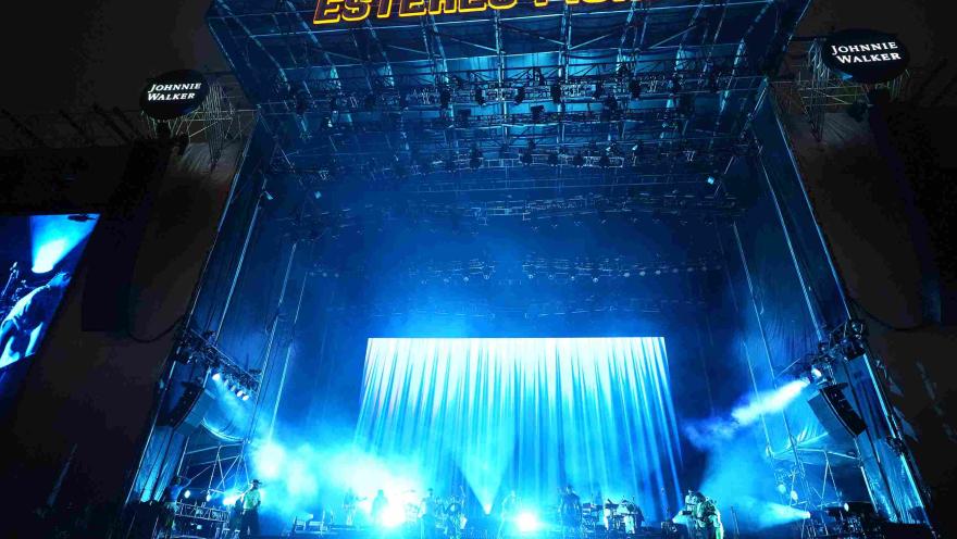 Escenario principal de Estéreo Picnic iluminado en azul, con banda en vivo y gran pantalla de fondo.