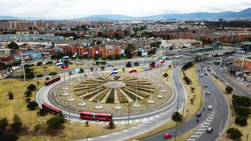 Vista aérea del Monumento a las Banderas en una rotonda, rodeado de vías y tráfico en la ciudad.