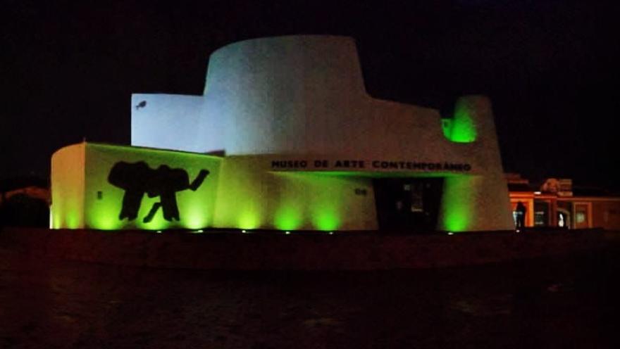  Fachada del Museo de Arte Contemporáneo iluminada de noche con luces verdes.