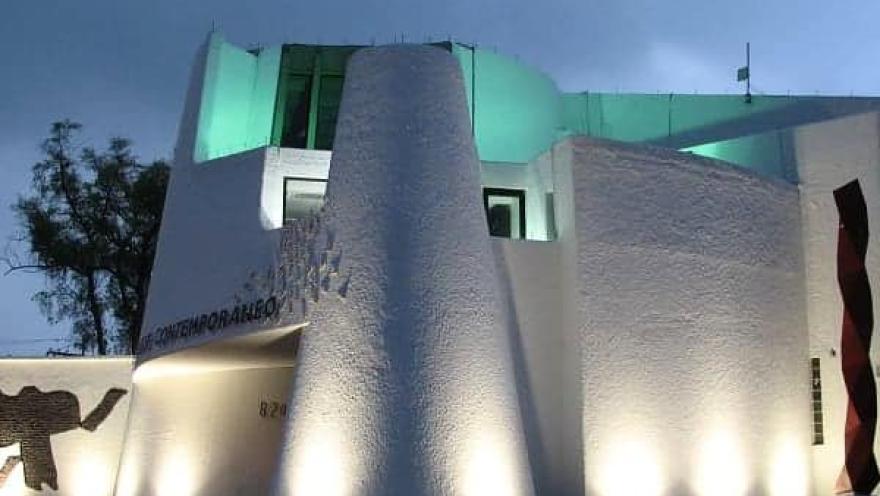 Edificio del Museo de Arte Contemporáneo iluminado de noche con luces blancas y verdes.