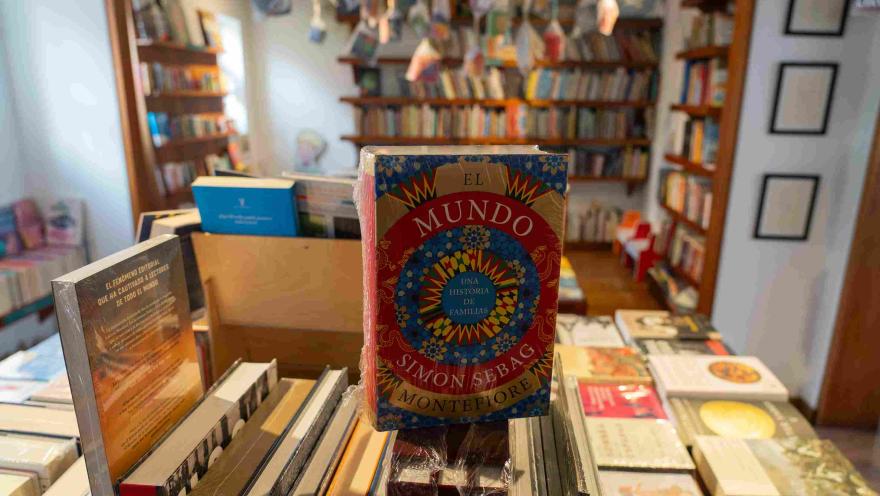 The book "The World" by Simon Sebag Montefiore in the foreground on a table, with bookshelves out of focus in the background of a bookstore.