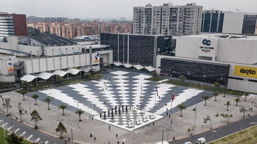 Vista aérea del centro comercial Gran Estación en Bogotá, con una amplia plaza central de diseño geométrico rodeada de edificios y vías urbanas.