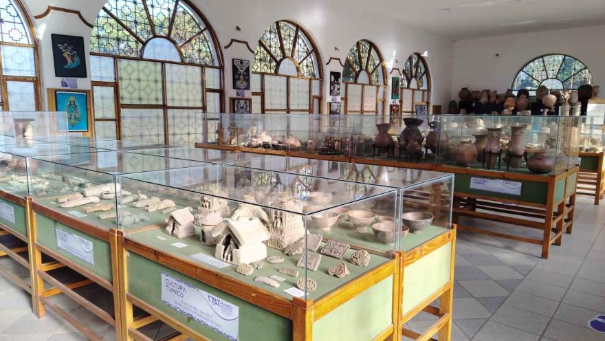 Un museo con numerosas vitrinas de vidrio llenas de diversos artefactos históricos.