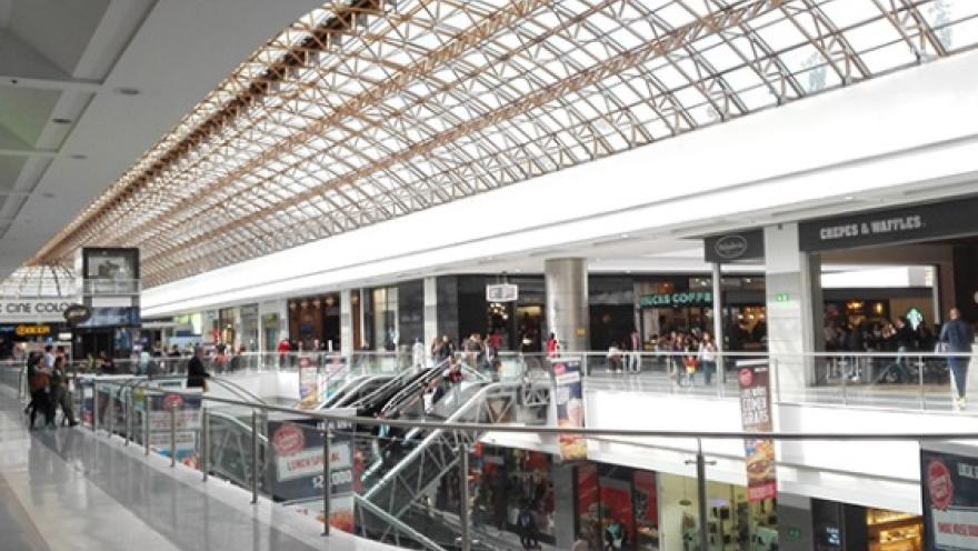 Interior del centro comercial Gran Estación en Bogotá, con amplios pasillos, locales comerciales y una cubierta de vidrio que ilumina el espacio.