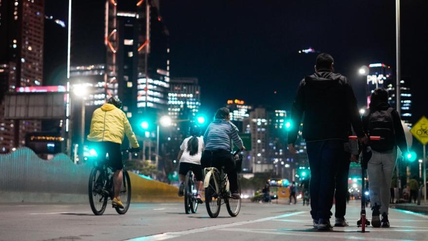 Personas recorren las iluminadas calles de Bogotá durante la ciclovía nocturna, una jornada que transforma la ciudad en un espacio de encuentro, deporte y disfrute urbano bajo el brillo de sus rascacielos.