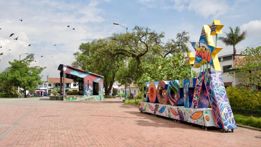 Plaza de Bosa en la que destaca un aviso con letras coloridas que forman la palabra Bogotá. Es un escenario cultural y con árboles, en un entorno abierto y urbano.