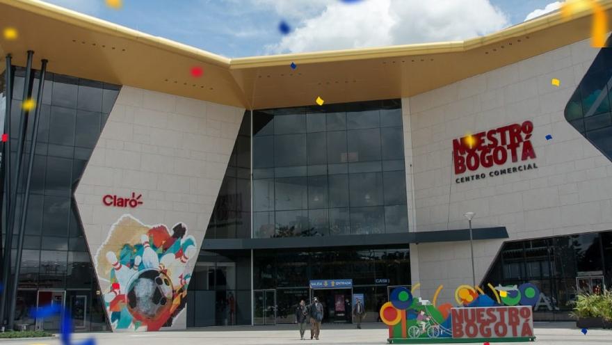 Fachada moderna del centro comercial Nuestro Bogotá, con amplios ventanales, diseño contemporáneo y decoración colorida en la entrada.