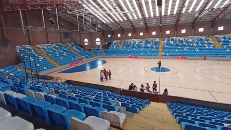 Vista interior del Coliseo Cayetano Cañizares, un moderno escenario deportivo con amplia cancha multipropósito y graderías de sillas azules, diseñado para competencias, entrenamientos y eventos de gran afluencia en Bogotá.