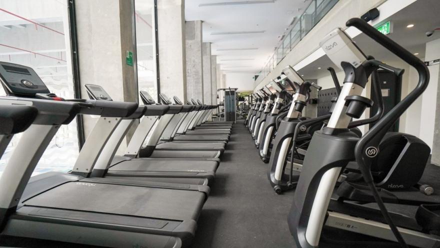  Moderno gimnasio del Centro Felicidad Cometas equipado con caminadoras y máquinas de entrenamiento cardiovascular, en un espacio amplio, iluminado y diseñado para promover la actividad física y el bienestar de los usuarios.