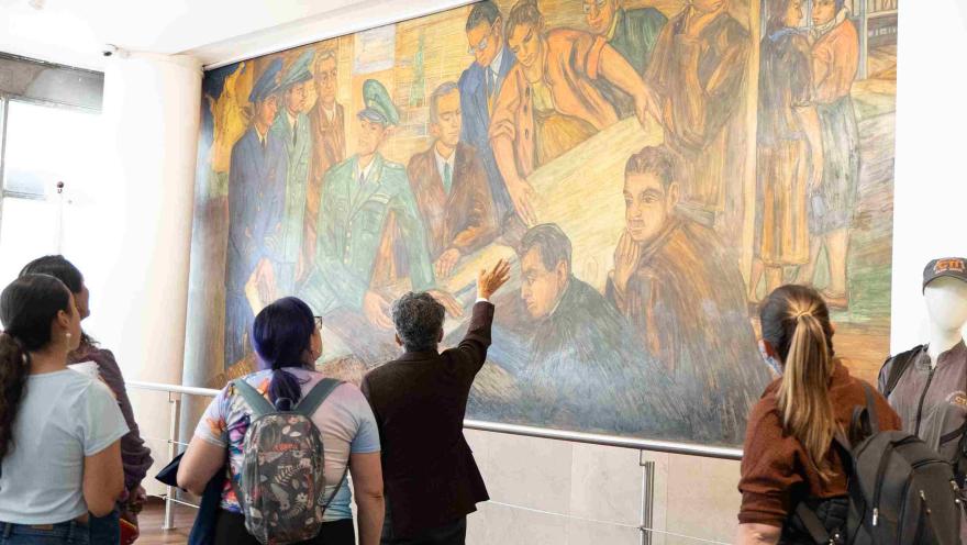 Visitors view a large mural during a guided tour of a museum in Bogotá.