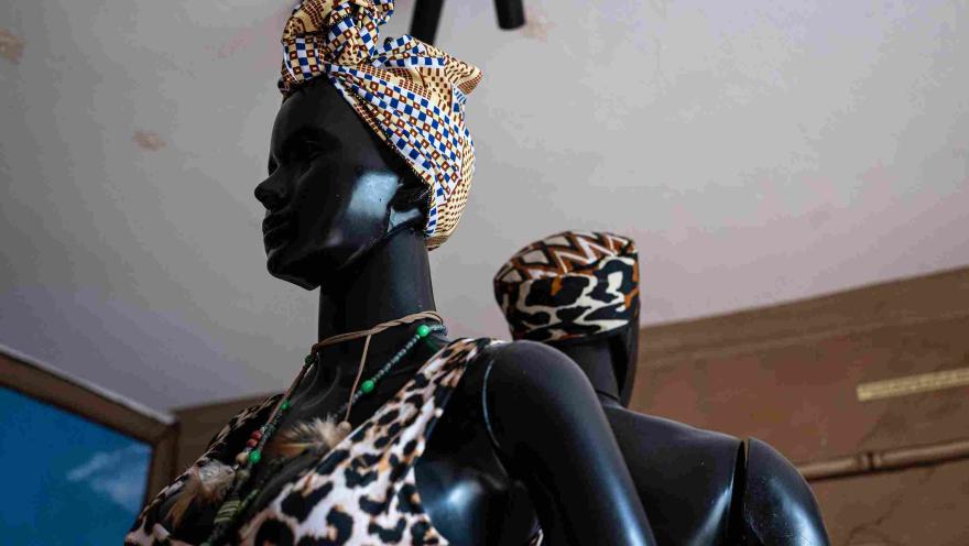 Maniquíes exhiben prendas y accesorios inspirados en la moda afrocolombiana, con turbantes, estampados y collares tradicionales en una muestra cultural.