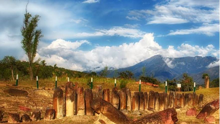 Vista del Observatorio Solar Muisca con monolitos de piedra alineados en un paisaje montañoso, bajo un cielo azul con nubes.