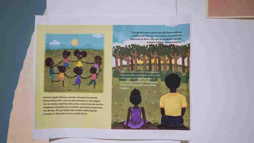 Ilustración de un libro infantil abierto con escenas de niñas y niños afrodescendientes jugando y compartiendo, acompañadas de textos sobre su historia y tradiciones.