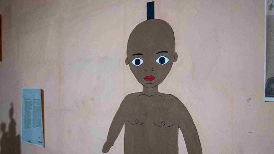 Ilustración de una figura humana afrodescendiente con grandes ojos y labios rojos, exhibida sobre una pared como parte de una muestra artística y cultural.