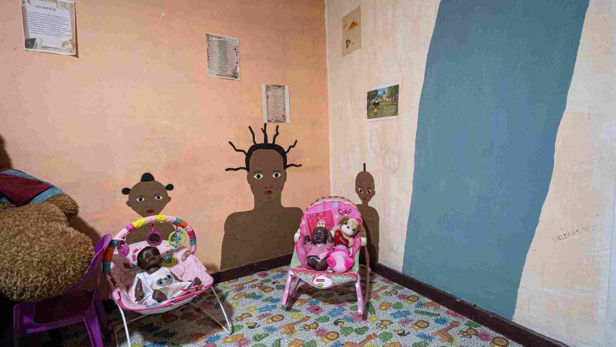  Espacio expositivo con ilustraciones de personajes afrodescendientes, muñecas y juguetes infantiles que resaltan la identidad, la diversidad y la representación cultural afrocolombiana.