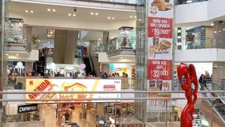 Una vista interior del Centro Comercial Avenida Chile, donde tiendas, espacios abiertos y elementos artísticos crean un ambiente moderno y dinámico.