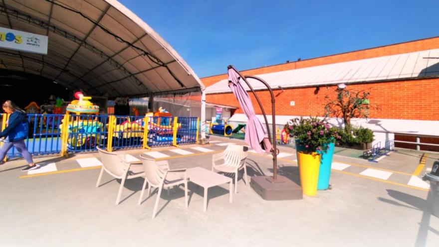 Una terraza al aire libre combina mesas, zonas de descanso y juegos infantiles, creando un espacio familiar para disfrutar en Tintal Plaza.