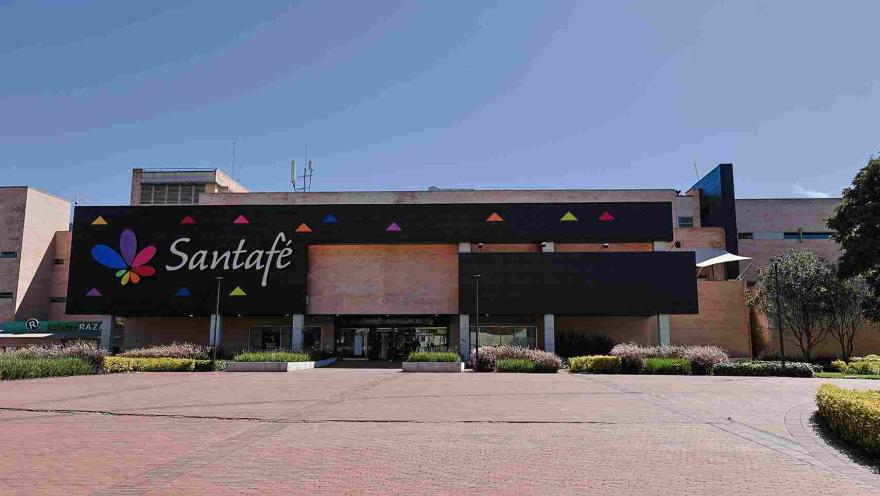  La fachada del Centro Comercial Santafé combina una arquitectura contemporánea con amplios espacios abiertos, jardines y una imagen colorida que refleja el ambiente moderno y familiar del lugar.
