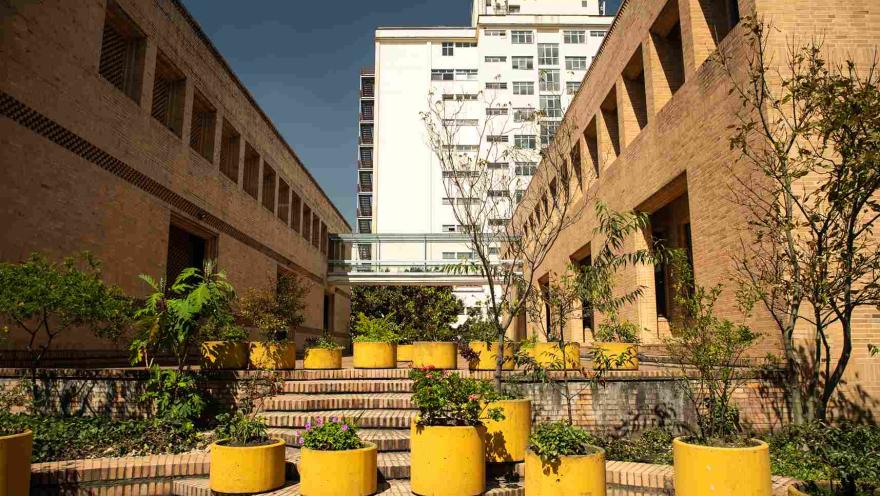 Patio del Archivo General de la Nación, con jardines, escaleras y edificios de ladrillo que enmarcan el espacio.