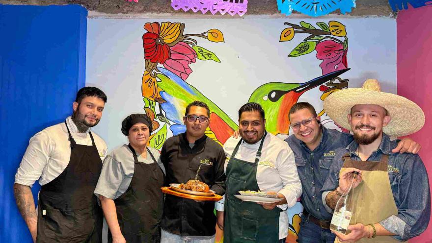 The team at Don Bigotes posing alongside their culinary preparations.