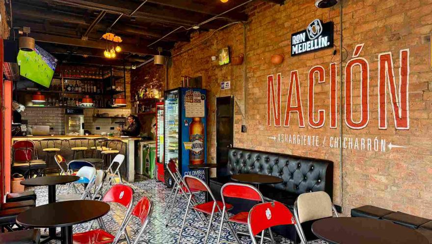 Interior de Chicharrón de Nación, con mesas, barra y decoración de estilo urbano.