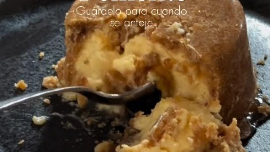 A dessert with a creamy and golden texture, served with a generous portion of sweet sauce and crunchy bits to enjoy by the spoonful.