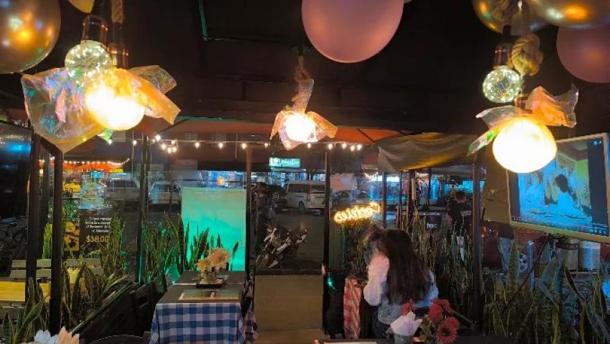 Foto1: Interior de Gaia Bogotá, con mesas decoradas, iluminación ambiental, elementos festivos y pantallas que crean una atmósfera moderna y animada.