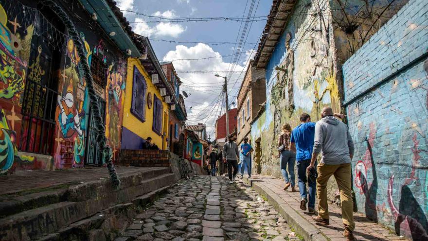 Callejón del Embudo, en La Candelaria, con sus calles empedradas y coloridos murales que reflejan el arte y la historia de Bogotá.